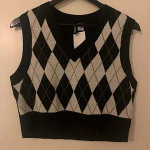 Stickad väst - En stickad väst med rutigt mönster. Den är croppad och är därför lite kortare i modellen😇 säljer denna då det inte riktigt var min stil! Helt oanvänd, prislappen är kvar!