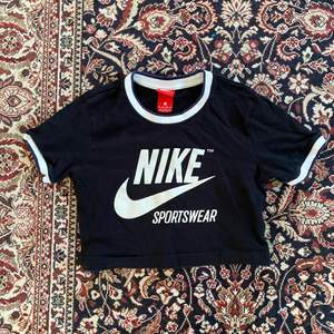 En croppad T-shirt från Nike i svart färg. Fint skick. 