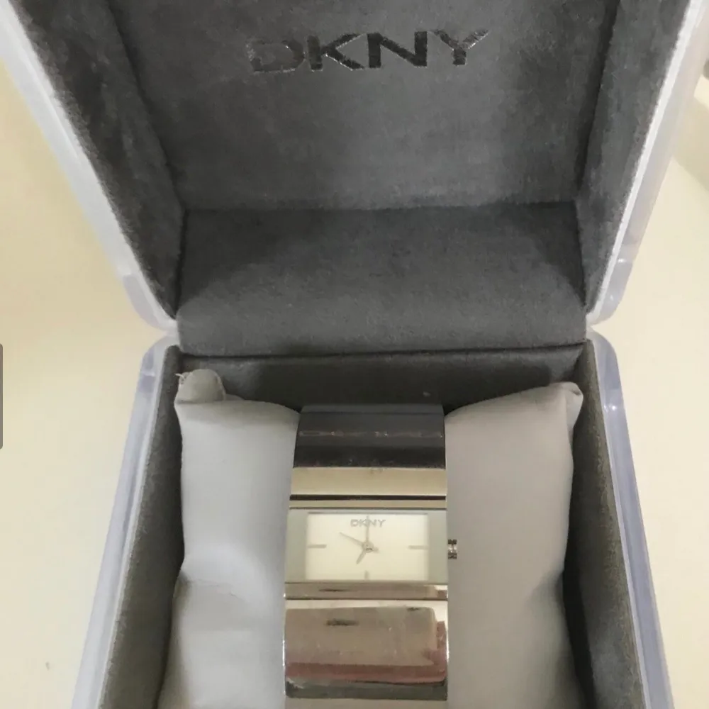Jättefin klocka från DKNY, Donna Karan, som ett silverarmband. Urtavlan i ljus silver. Använd några gånger men i bra skick, lite småreparationer men inget som stör utan blir av normal användning. Batteriet kan behövas bytas. Fungerar såklart. Inköpt på Stjärnurmakarna i Täby C för 2500:-, kvitto finns. Självklart äkta, kommer i jättefin ljusgrå originalbox med extra länk om man behöver länga den.  Skickar med posten mot porto, fri frakt gäller upphämtning vid Stadion /Tekniska eller Täby c Stock. Accessoarer.