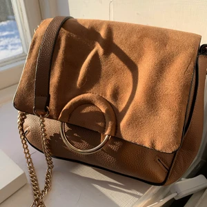 Väska - Så fin väska! Ljusbrun färg och guldetaljer, väskan har ett långt band som inte går att justera, superfin till vilken outfit som helst!💕 Lent material överst, buda privat, om tillräckligt många blir intresserade startar jag en budgivning! Väldigt bra skick då den aldrig använts