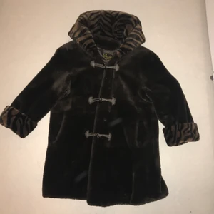Fuskpälsjacka  - Varm brun jacka med djurmönster på vrister och i luvan. Ena fickan är sönder inuti men går lätt att laga❤️ stor S