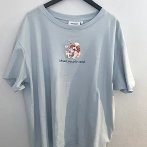 T-shirt - Ljusblå t-shirt med tryck från weekday, använd några gånger, i fint skick. Storlek S men är väldigt oversized så passar större storlekar också. 