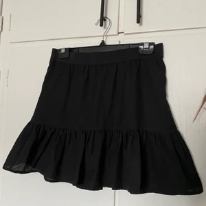 Svart volangkjol - Svart volanjkjol. Oanvänd. Katt finns i hemmet.