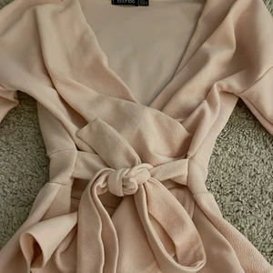 Omlott blus från boohoo.  - En elegant blus som ger en vacker figur. Använd vid ett dop. Storlek S passar även Xs. Slits i ärmarna. Knuten går att reglera. Köpt för 140