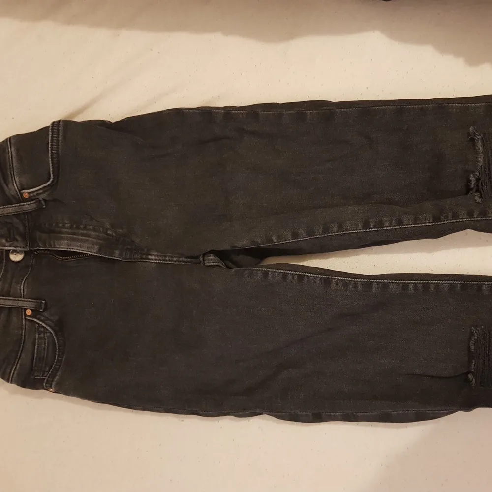 Ett par jeans som har hål i knäna och säljs för att de inte används . Jeans & Byxor.