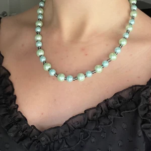 Pärlhalsband - Ett gullligt pärlhalsband som jag gjort själv i gröna, blåa och svart/gråa pärlor🥰 pärlat på elastisk tråd. 