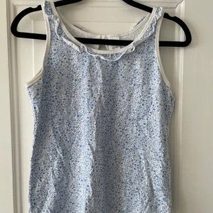 Småblommigt linne - Ett supergulligt linne med små blåa blommor💙 Köpt på Åhléns. Strl 158/ 164 men passar absolut xs och kanske även S. Säljer då det är för litet för mig, inte mycket använt💙