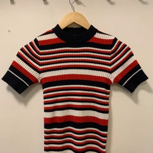 Randig stickad t-shirt - Säljer denna blå, vit och röd randiga t-shirten som jag köpt på Humana. Väldigt klassisk och använd endast ett fåtal gånger! 