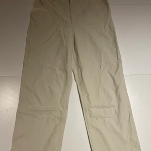 Beiga byxor i linneimitation, 40  - Det är ett par beiga byxor i storlek 40. De är lite kortare i benen. Materialet är en blandning mellan linne och jeans. 