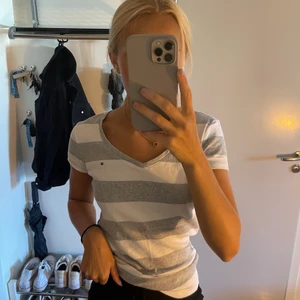 T-shirt hilfiger - Jag säljer min vit och grårandiga T-shirt från Hilfiger, knappt använd. Mest legat i garderoben, använd Max 2-3 gånger. V-ringad. Mycket fint skick