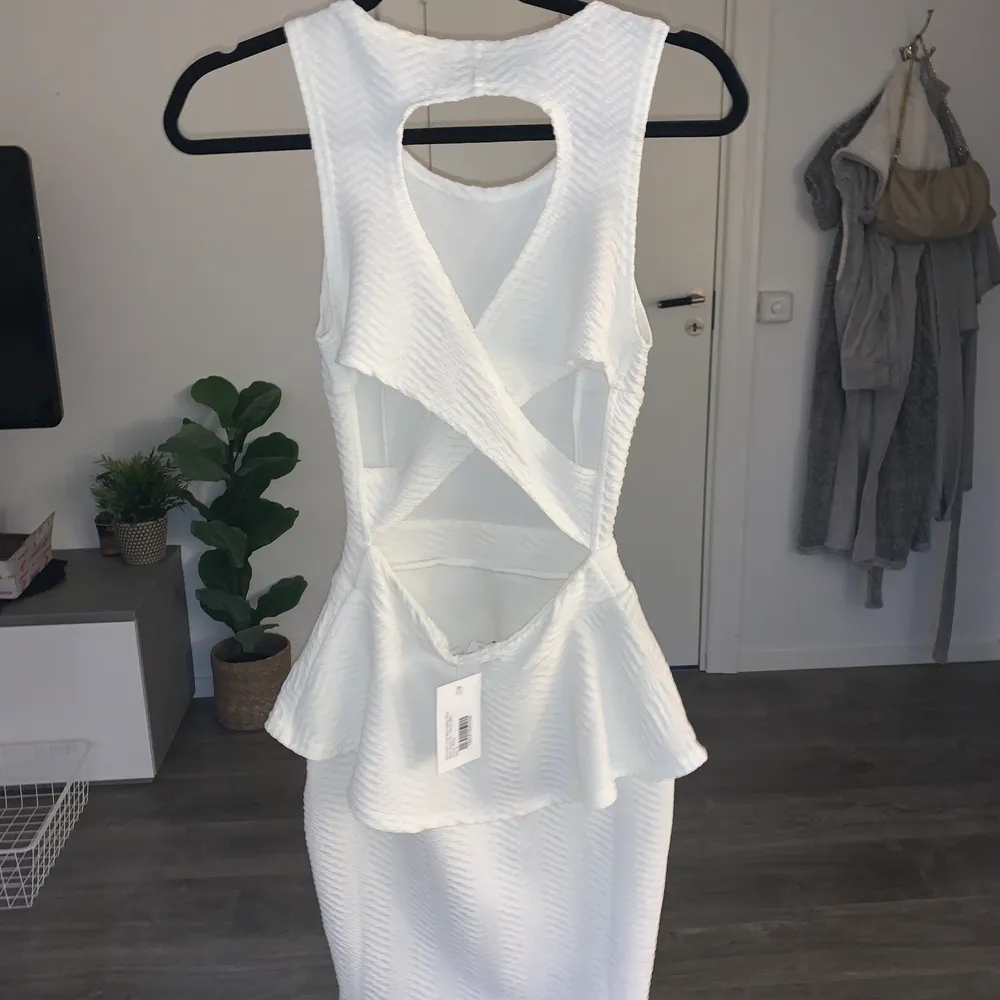 Jättefin vit klänning från Nelly i storlek S. Helt oanvänd med lappen kvar då den aldrig kommit till användning men verkligen snygg och superfin i ryggen! . Klänningar.