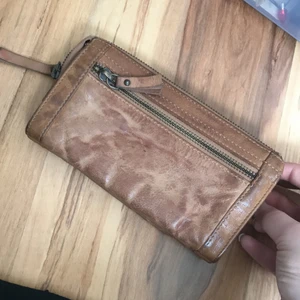 Plånbok  - Plånbok som jag har haft när jag rest, får plats med pass, sedlar, kort, mynt och smycken. Den ser sliten ut men det är så den ska se ut. 