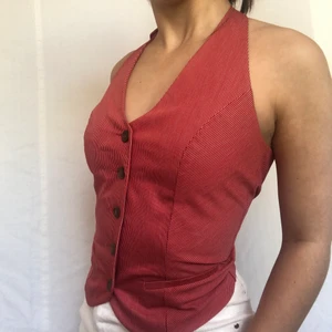 Väst - Underbar halterneckväst med röda pinnstripes. Om annonsen finns kvar finns plagget kvar! Köpare står för frakt. Som ny! Visas på en s