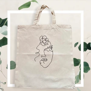 Vacker tygväska  - En vacker väska med motiv av en line art målning föreställande en kvinna med en pion i ansiktet.💞🌸Tygväskan finns i två storlekar, stor:38x42 cm(115kr) mindre:27,5x30 cm(89kr) Frakten såklart alltid gratis! Kontakta mig för mer info.💞 