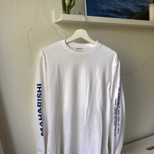 Maharishi långärmad t-shirt - Vit helt oanvänd långärmad t-shirt av märket Maharishi i storlek M (herr), med blå text på ärmarna. Tyvärr lite stor för mig, annars himla fin!