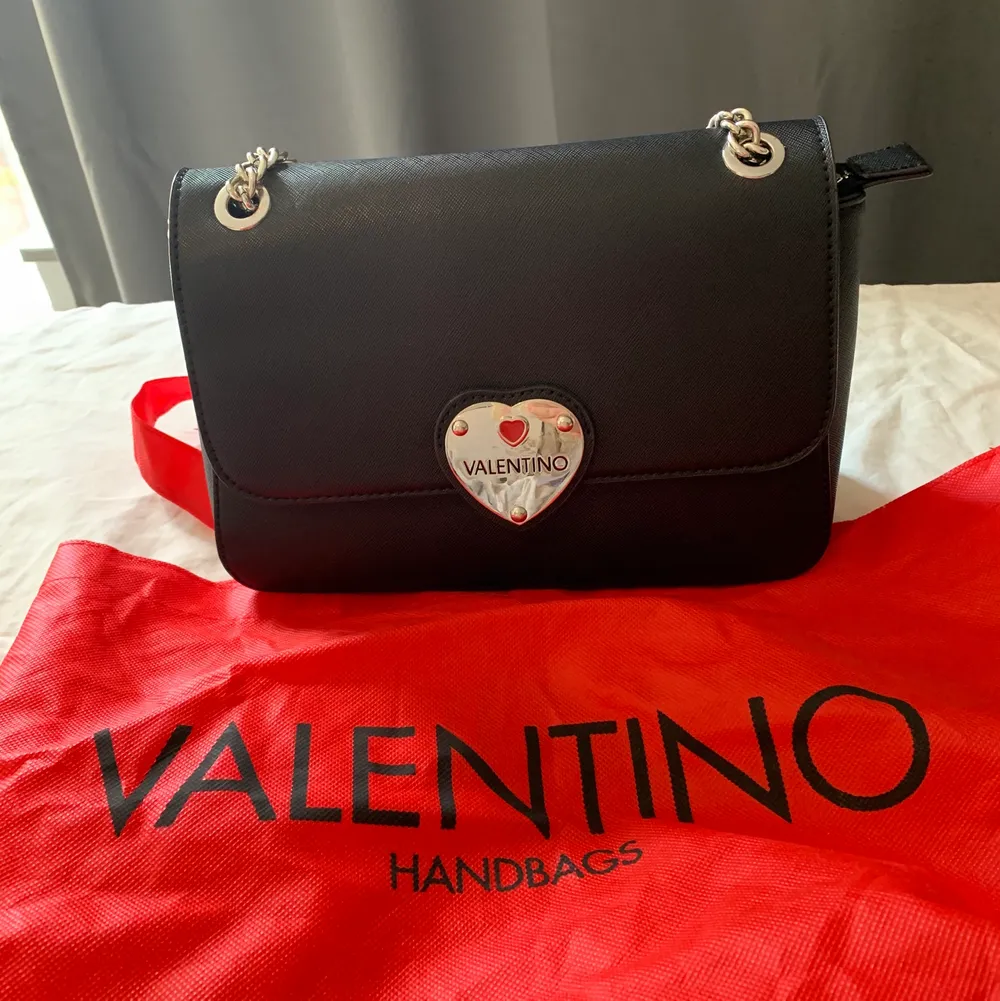 Valentino by Mario väska. Inköpt på Zalando för ca. 600kr. Användes sparsamt och i väldigt fint skick! Finns några mindre repor på metallhjärtat men inget man lägger märke till vid första anblick.  Väskan går att ha både som handväska och axelremsväska tack vare de justerbara kedjorna. Dustbag finns.. Väskor.