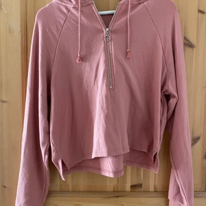 Tröja från Bikbok i strl M - Säljer denna tröja som är gammalrosa. Fin dragkedja detalj på framsidan och med en luva på baksidan. Skönt och luftigt!