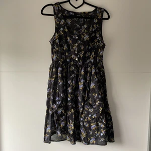 Blommig klänning - Svart sommarklänning med blåa blommor och små fickor på kjolen. Tyget är lite tunnare vilket gör den perfekt till sommaren! Kan mötas upp i Göteborg/Nyköping alternativt skicka om kund står för frakt 🌼