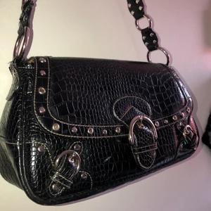 Väska med nitar  - Så fin väska med ish nitar. Väskan är bra skick förutom en slitning på sidan (se sista bilden). Väskan är ganska stor (32cm bred) och jag har kunnat få plats med allt från flaskor till kläder. Köpt secondhand i usa💕