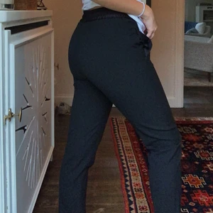 Svarta kostymbyxor från Filippa K - Säljer dessa jättesnygga kostymbyxorna från Filippa K. Byxorna är i strl XS, i ”tulpanfit”. Två sömmar följer längs framsidan på benen. 🦋 Så eleganta. Använda ett par gånger, säljer på grund av att jag tyvärr växt ur dem. 🧡