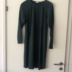 Filippa K klänning mörkgrön M - Mörkgrön klänning från Filippa K i storlek M. Knappt använd, fållen nertill och på en av ärmarna har gått upp men kan enkelt sys upp igen. 