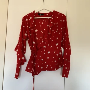 Blus från missguided stl 34 - Röd blus med stjärnor på från missguided i storlek 34. plagget tvättas innan det skickas iväg 