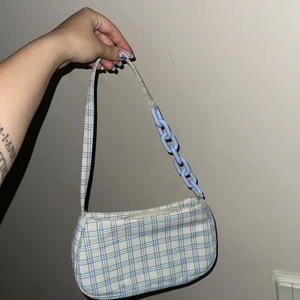 Rutig axelväska  - ⚠️MASS FÖRSÄLJNING PGA FLYTT⚠️ söt väska med blå kedja samt blå rutig. Lite smutsig pga att den varit bortlagd under lång tid. 