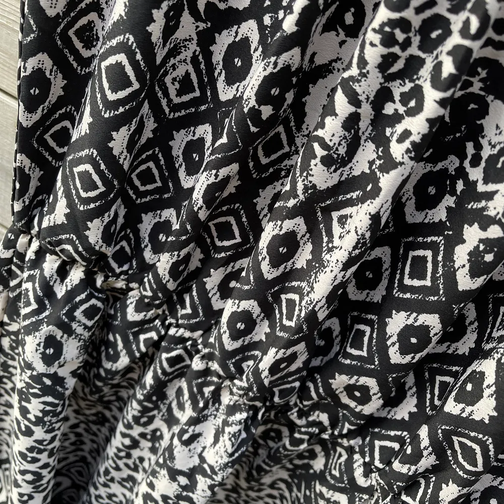 En svartvit multimönstrad klänning, passar strl S/M. Klänningar.