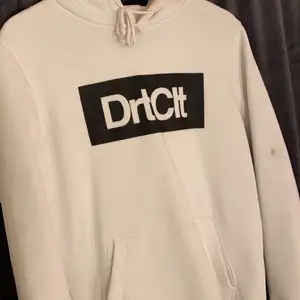 En vit dirtcult hoodie med svart text, den är i storlek M. Använd några gånger men inget som syns på den förutom nått litet svart märke på armen (se bild 2).