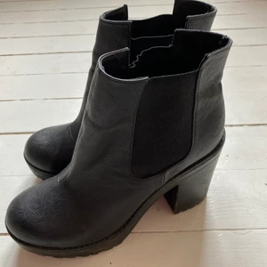 Svarta boots hm - Svarta boots med hög klack i gummi från hm. Sköna trots att de är höga. Använda men i bra skick. Pris inkl frakt 