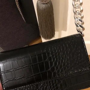 Svart väska med kedja - Säljer min fina fina väska med kedja från ginatricot! Använd 1-3 ggr och är som ny! Nypris 400kr (LÅNADE BILDER)