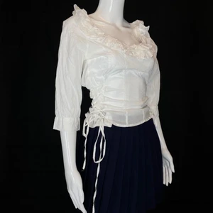 Blus  - Vit korsett-topp från Review, storlek 36. Diskret dragkedja på ena sidan.   Mått: Axel till axel 42cm, Ärmlängd 41cm, armhåla till armhåla 47cm, längd 56cm. Fri spårbar frakt. 