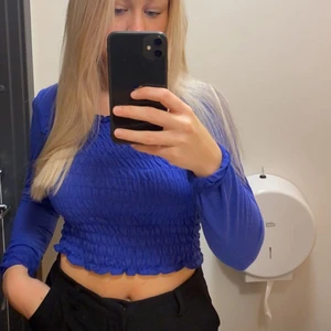 Topp - Säljer denna superfina blåa topp från Vero Moda i storlek XS. Har smock på magen och rygg och även ett band vid nacken som håller armarna uppe. ❤️
