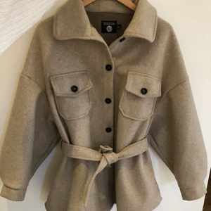 Kort Kappa  - Supersnygg kort kappa som är perfekt nu till våren! Kappan är i bra skick och är köpt från boohoo för ca ett år sedan. Den är i modell tall (strl 36) och passar bra på mig som är 170 cm. Nypris 600 kr och mitt pris är 300. Köparen betalar eventuellt frakt. Hör av dig om du har frågor och är intresserad!❣️