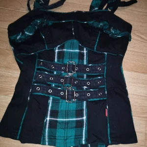 Tripp top grön svart - I begagnat skick. Axelband går att justera stl M dragkedja bak. Ej stretching 