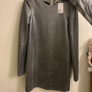 Klänning metallic  - Klänning med ”metallic” tyg och axelvaddar, aldrig använd. 