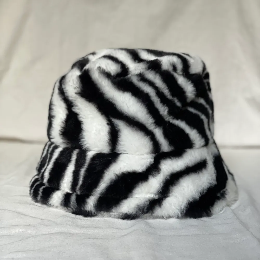 Supertrendig zebramönstrad bucket hat i fuskpäls. Helt oanvänd, storlek M-L. 150kr. Accessoarer.