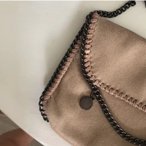 Trendig Väska - Trendig Crossbodyväska med kedja och ett fack. Något skimrig. Aldrig använd så i fint skick! OBS fake. Kan mötas i Uppsala eller frakta.