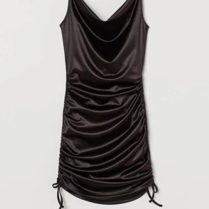 Klänning  - En jätte snygg kort klänning i satin med draperad urringning. Dragsko längst med sidorna.