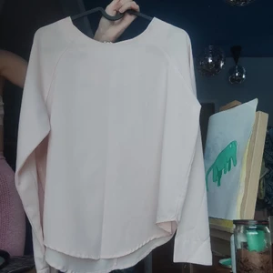 Blus i ljusrosa - Luftig blus i ljusrosa,har en dragkedja på ryggen.