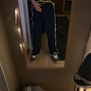 Nike byxor - nike byxor. med vita tunna ränder på sidorna, och innanför mellan dom 2 vita tunna ränderna så är det en rand som är lite tjockare av ljus ljus rosa som visas på 3e bilden… vilket är sjukt snyggt och har aldrig sett något annat klädes märke som använder sig av sån ljus och snygg rosa. i flesta fall är rosa inte något snyggt då det brukar vara för stark även om det är ljus rosa. tack 💡🤌🌎