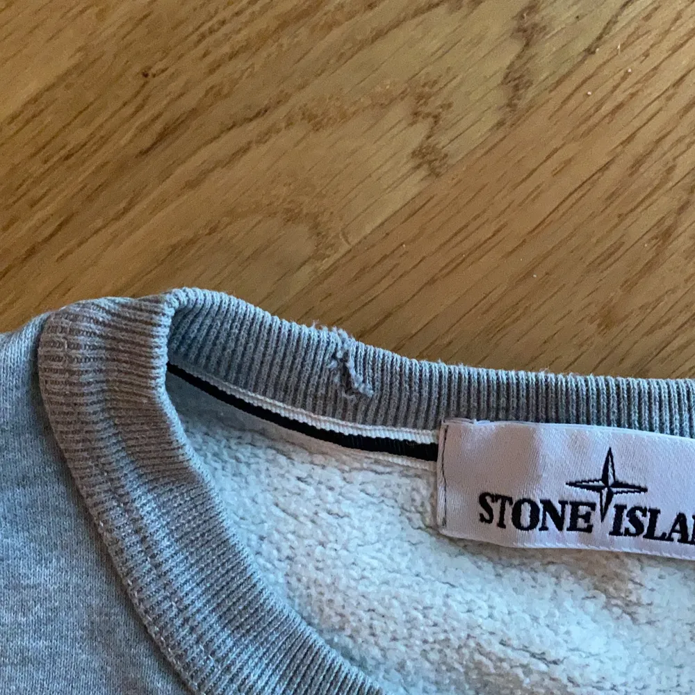 Stone Island tröja i ljusgrått, använd men i övrigt bra skick förutom ett litet hål på insidan av kragen, se bild 2, syns alltså inte när man har på sig den, Herr i strl L, men skulle säga är mer som en M. Tröjor & Koftor.