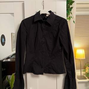 En snygg svart skjorta i en kortare modell🌼 Den är liten i storleken. Frakt tillkommer 🚚