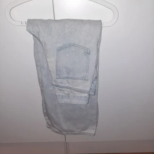 Ett par jeans - Ett bar blåa med lite mörkblåa fläckar, bagge jeans. 