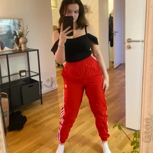 Adidas trackpants - Röda trackpants från adidas i storlek XS. Supercoola!! Har fickor på vardera sida samt snörning i midjan. Sparsamt använda.