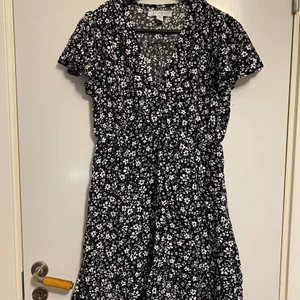 Klänning  - Blommig klänning i storlek 36 från New Yorker. Luftig o lätt tyg, klänningen går ned till knäna ungefär. V- ringad . Använt endast 2 gånger på sommaren 2021.