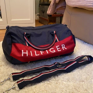 Väska ifrån Tommy Hilfiger - Väskan passar till allt ifrån träning till skolan! Måtten är ca 30 x 22 vilket jag skulle säga är mellanstorlek och band ingår såklart💙