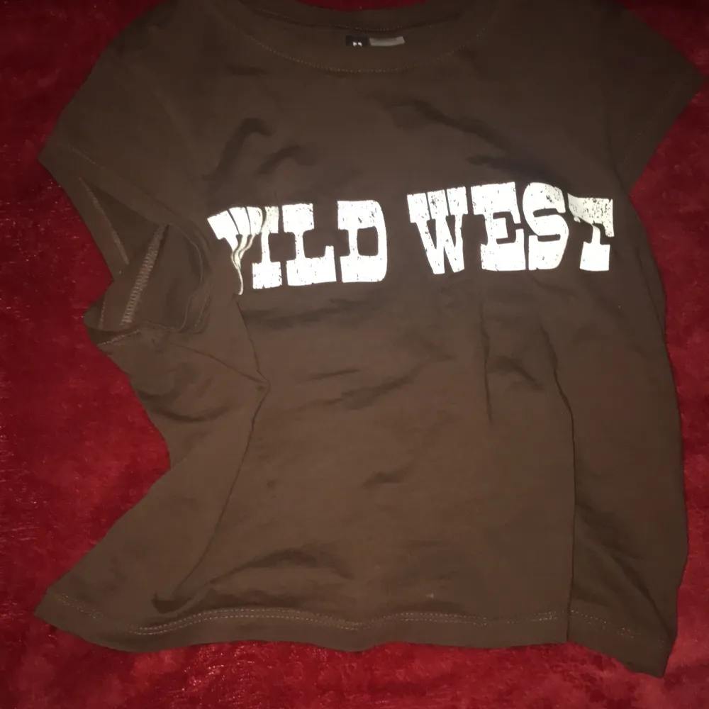 Wild West croppad Tee, den är bekväm och den passar med en vit tröja under!! Den är super lätt att style.  Den passar bra i vinter och på sommaren.  Har bara använt hemma.. T-shirts.