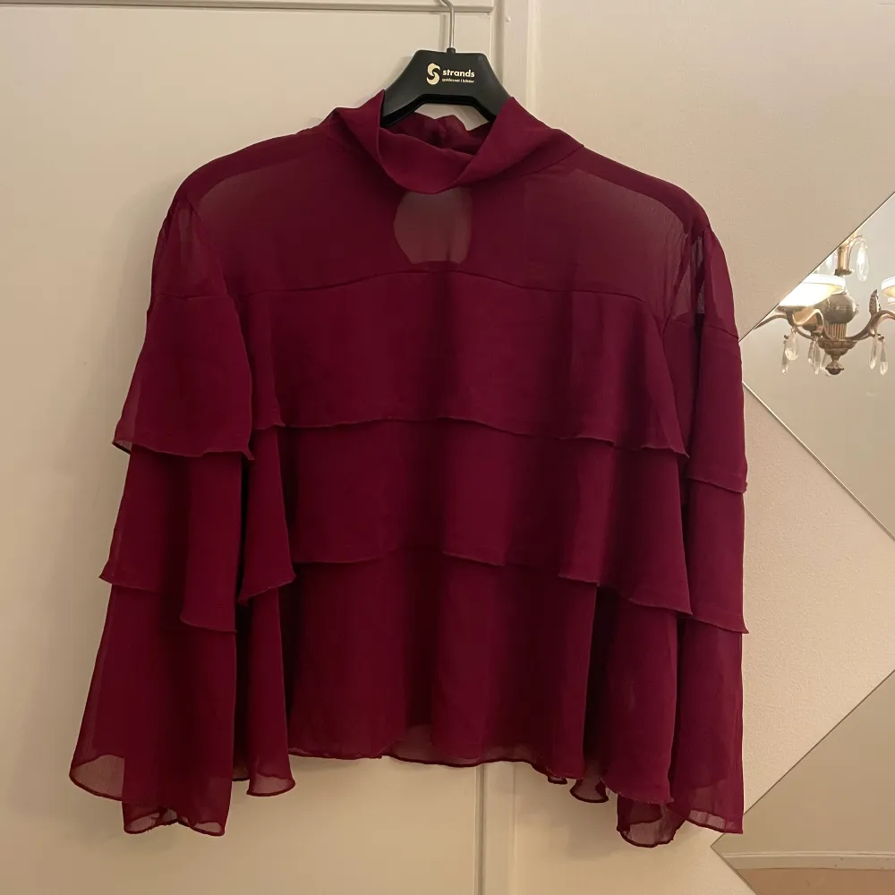 Supersnygg burgundy blus som är sheer förutom över brösten där det finns tyg under. Flera lager och lös och luftig. Ärmarna är luftiga som ni ser på bild. Älskar denna men säljs för den kommer aldrig till användning.. Blusar.