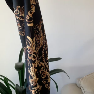 Svartguldig scarf - Stor svart scarf som jag tänkte använda som topp men aldrig kom till att göra. Superkvalitet och helt utan defekter. Kan mäta om mått önskas men skulle uppskatta att den är mellan  60-80cm lång och bred. Frakt ingår i priset
